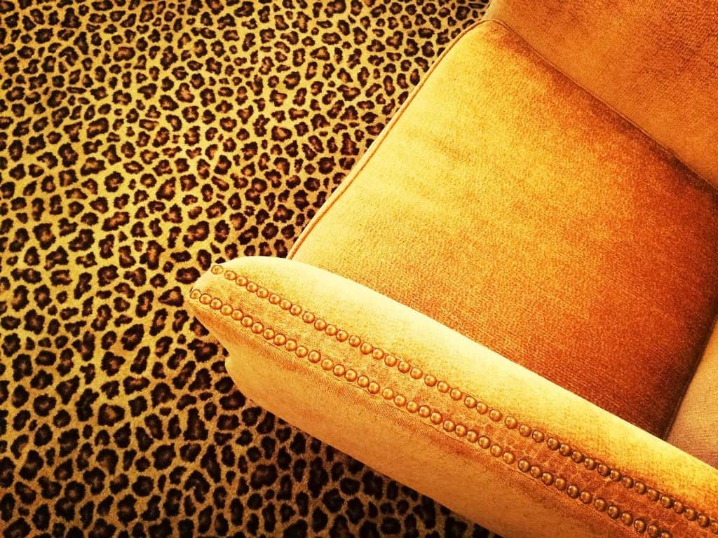 Orange velvet armchair on leopard carpet