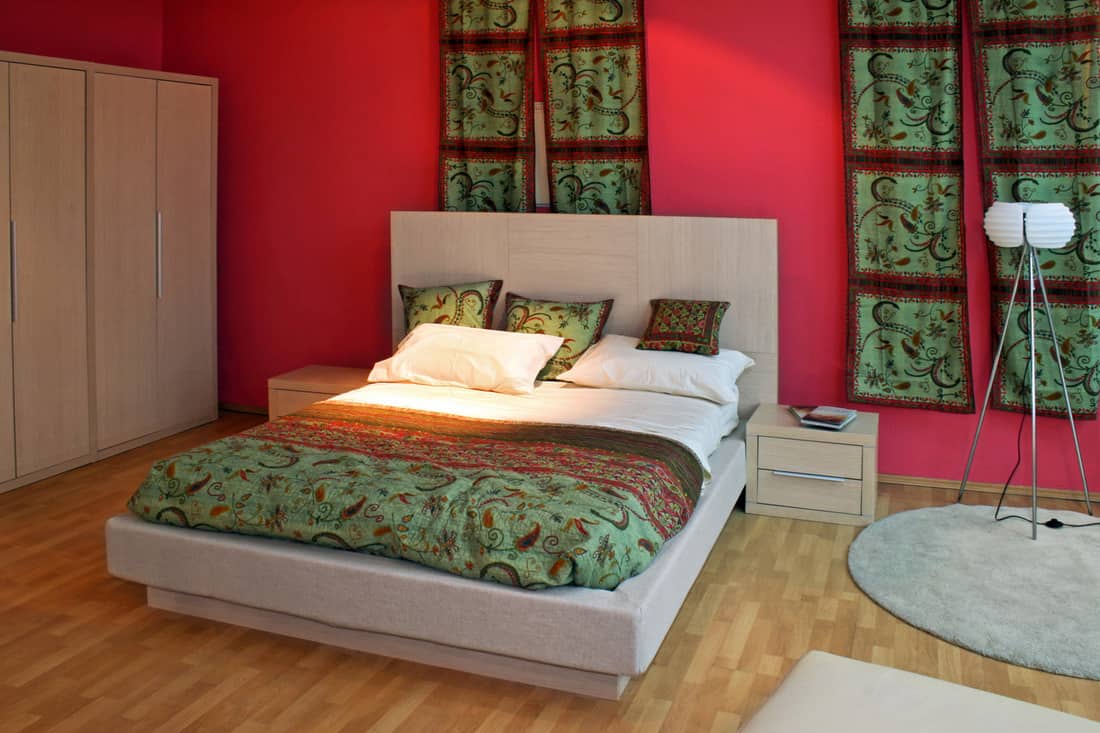 Oriental bedroom with red walls and green curtains