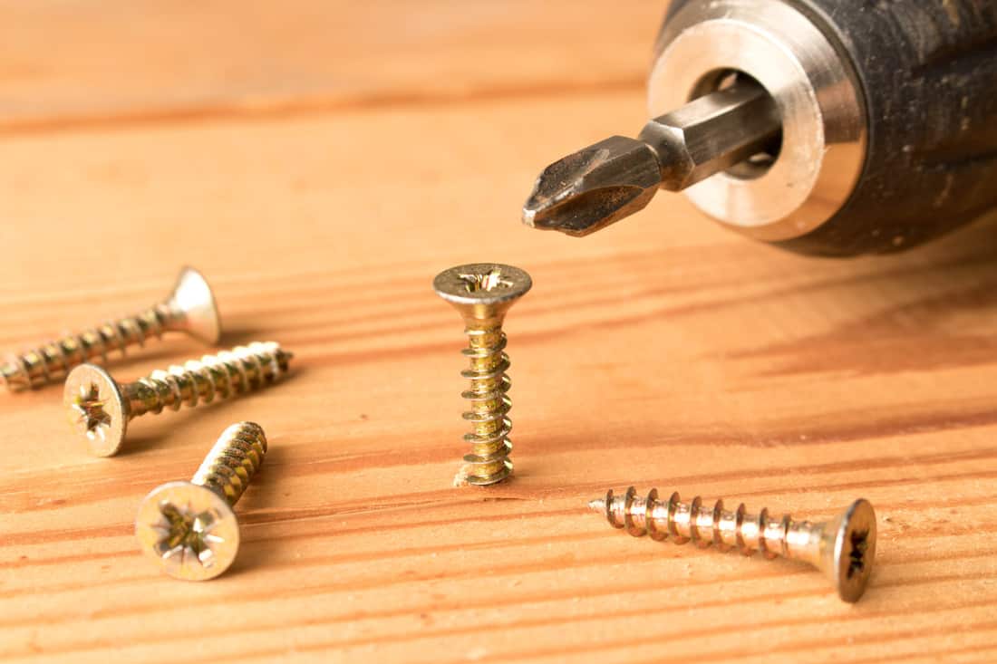 Screwdrivers and screws on a wooden table. The concept of work.