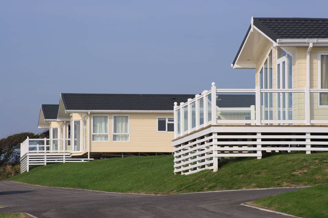 Small country rest houses with wooden panel sidings and dark PVC roofing, Can You Walk On PVC Roofing?
