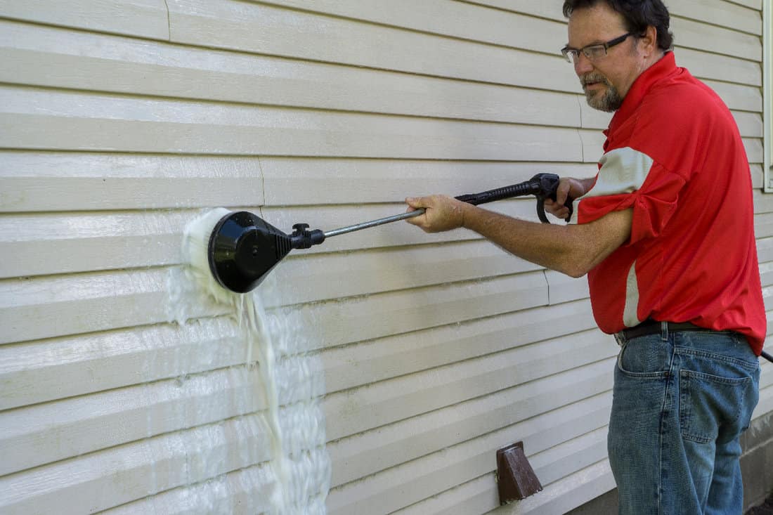 Using a high pressure brush to remove algae and mold
