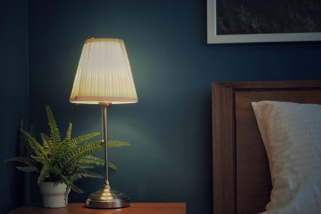 Vintage​ lamp​ on​ the​ wooden​ bedside table