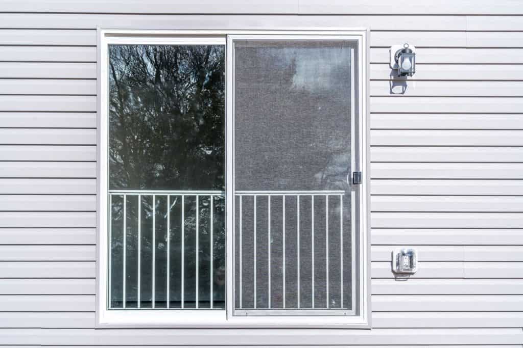 White sliding screen door and a wall with white sidings