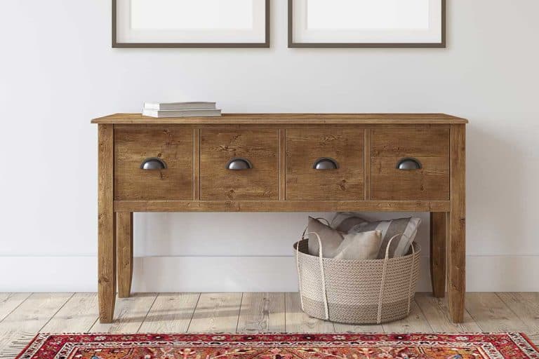 Wooden console table near white wall with two blank frames, Standard Entryway Table Dimensions [How Deep, High and Wide]