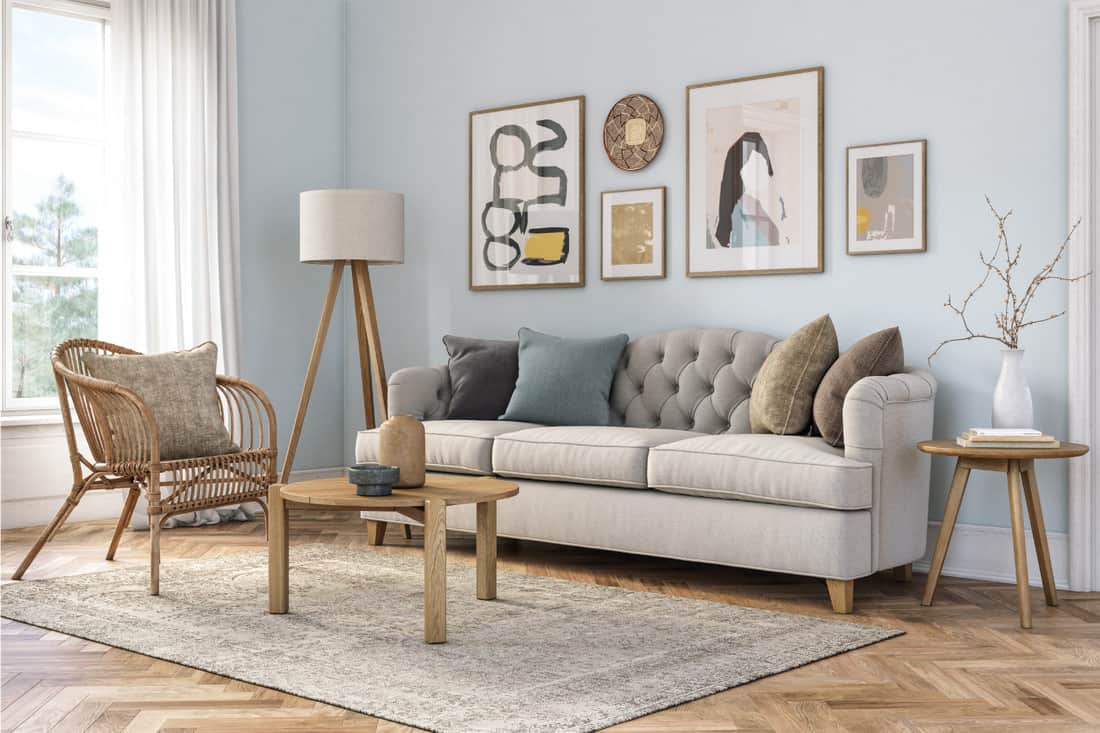 Beige colored furniture and wooden elements and light blue colored wall with wall art