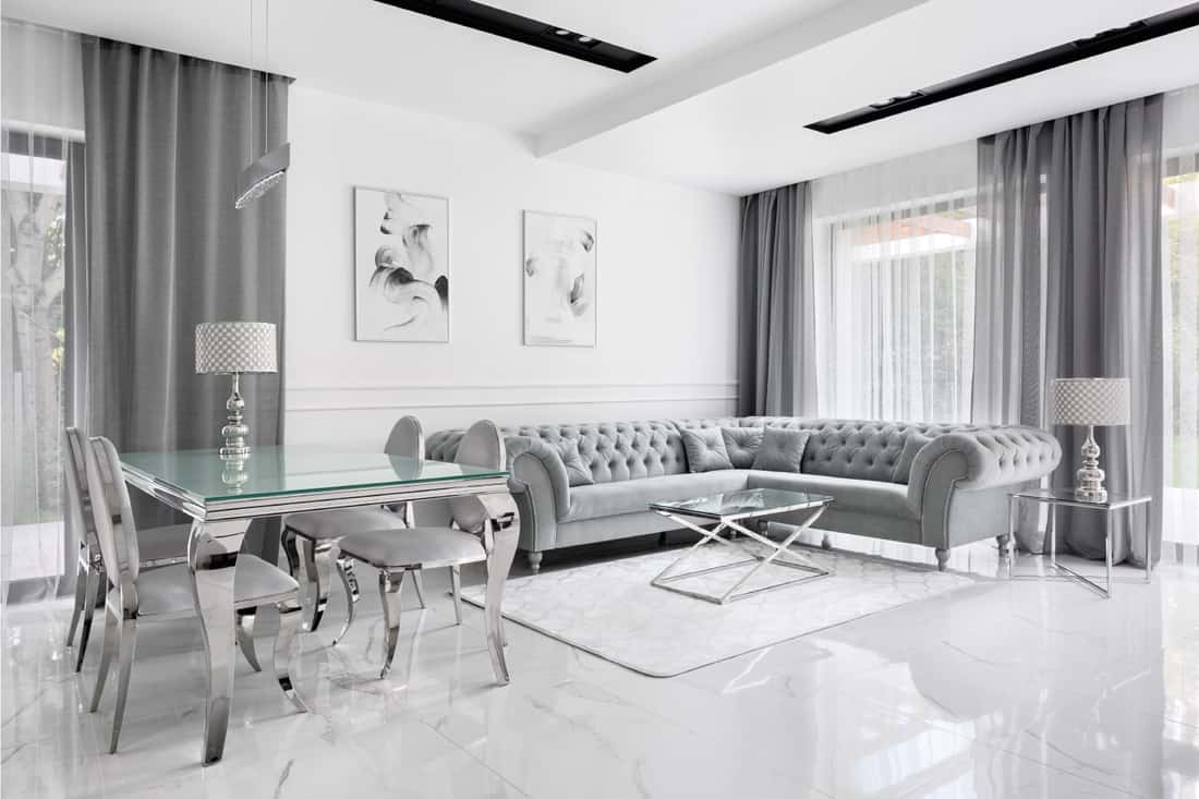 Luxury living room in gray and white with glass table and glamour style corner sofa