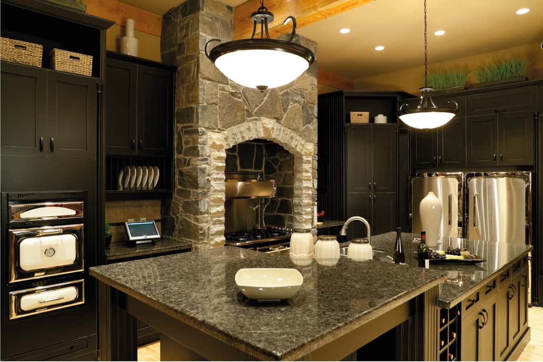 Marble counter tops, rock chimney, black cabinets kept in stone