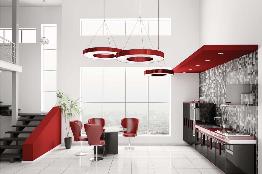 Modern kitchen with red sculpted chandeliers and chairs, black cabinets, white floor and walls