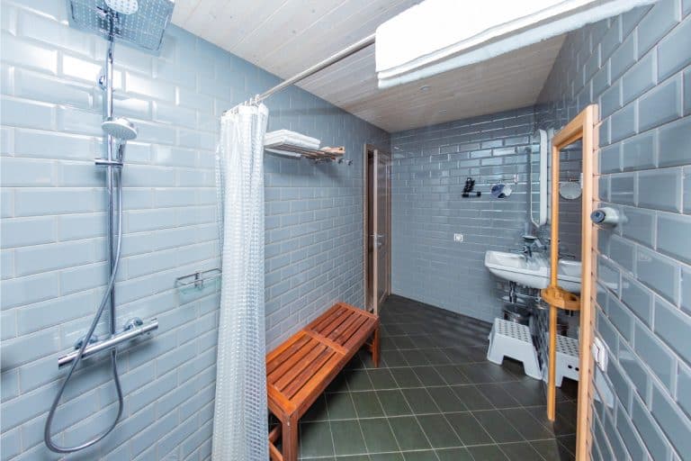spacious bathroom with shower curtain and wooden bench, Should You Oil or Stain a Teak Shower Bench