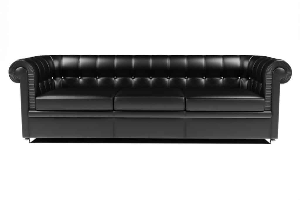 Traditional black leather couch against a white background