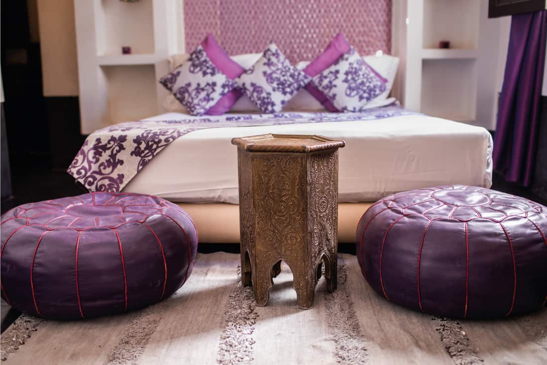 Traditional Moroccan style beautiful deluxe bedroom interior decorated with arabian motifs, textured pillow, blankets and rug