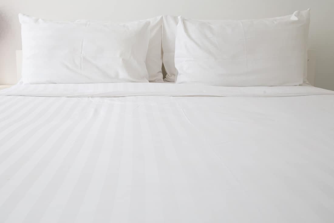 White flannel sheets and white pillows in bed, How To Wash And Soften Flannel Sheets To Keep From Pilling