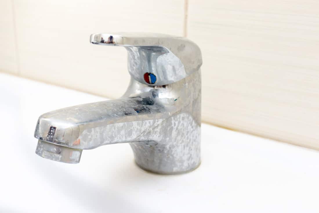 A bathroom faucet with water stains on the chrome finish, How To Get Water Spots Off Bathroom Fixtures [5 Easy Steps]