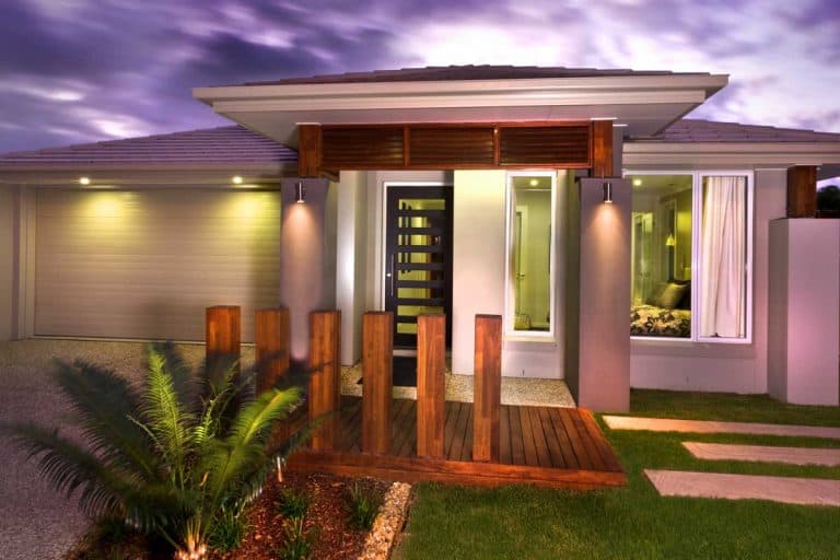 A beautiful view of a home at dusk from front with a garage, What Does A Green Porch Light Mean?