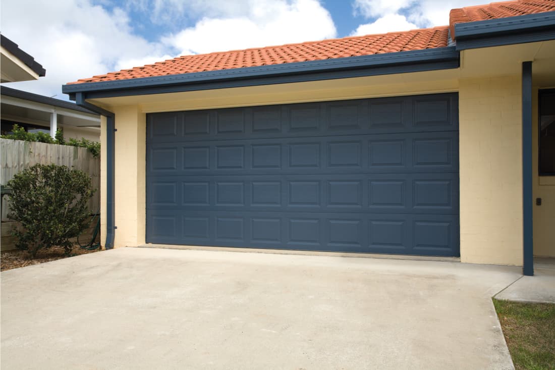 A blue double garage door on a brand new home
