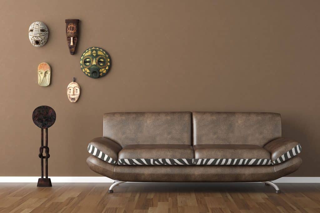 A dark brown colored living room with a dark leather sofa