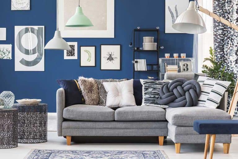A designer metal tables near gray corner couch in spacious living room with gallery on blue wall, 11 Gorgeous Gray Couch Living Room Ideas
