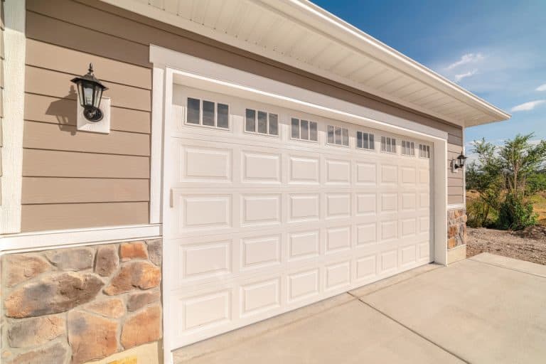 A double garage and driveway of a modern home on a sunny, clear day. Should The Garage Door Match The Front Door