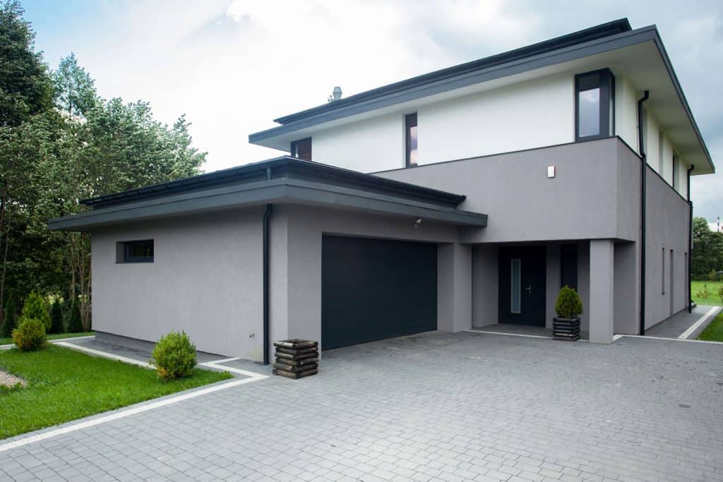 A huge two storey mansion with a contemporary design and an isolated garage section with a wide driveway