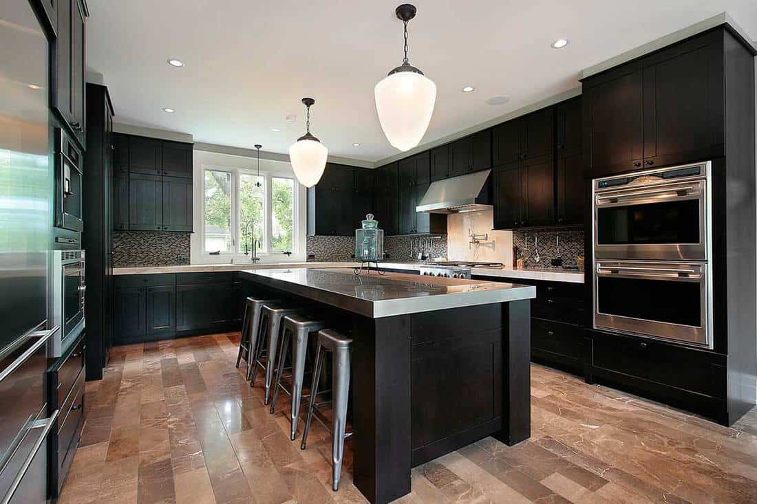 A kitchen with dark wood cabinetry, 11 Beautiful Kitchens With Dark Wood Cabinets