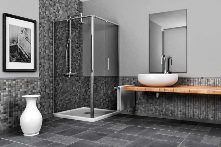 A large bathroom with gray tile floor, mirror over sink and shower with glass doors, 15 Great Gray-Tiled Bathroom Ideas