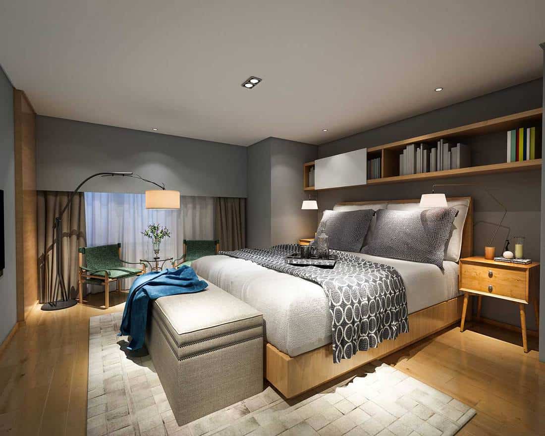 A modern interior design bedroom with floor lamp, wall shelves above bed, bedside table and carpet rug on wooden floor
