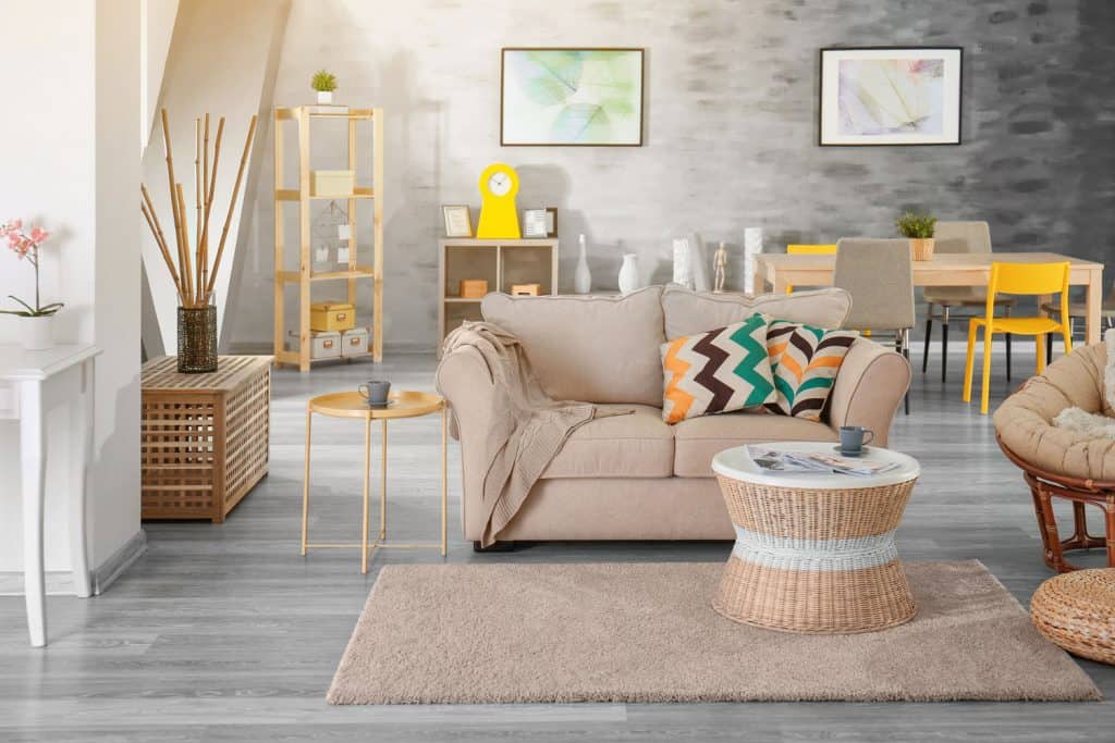 A modern contemporary themed living room with a brown sofa, brown coffee table, brown carpet inside a gray living room 