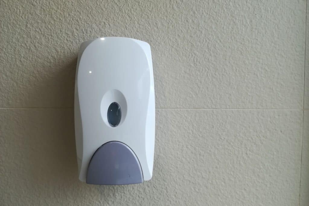 A white dispenser mounted on a wall
