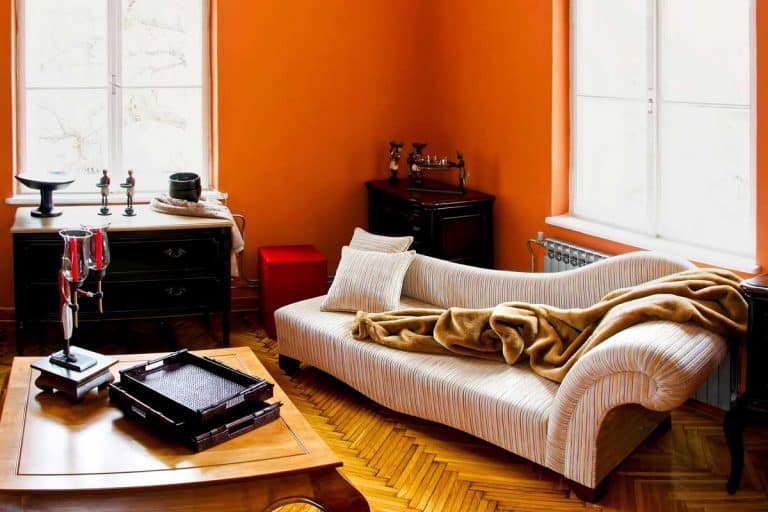 An orange room living room with parquet floor, sofa and wooden coffee table, 23 Eye-Catching Orange Living Room Ideas