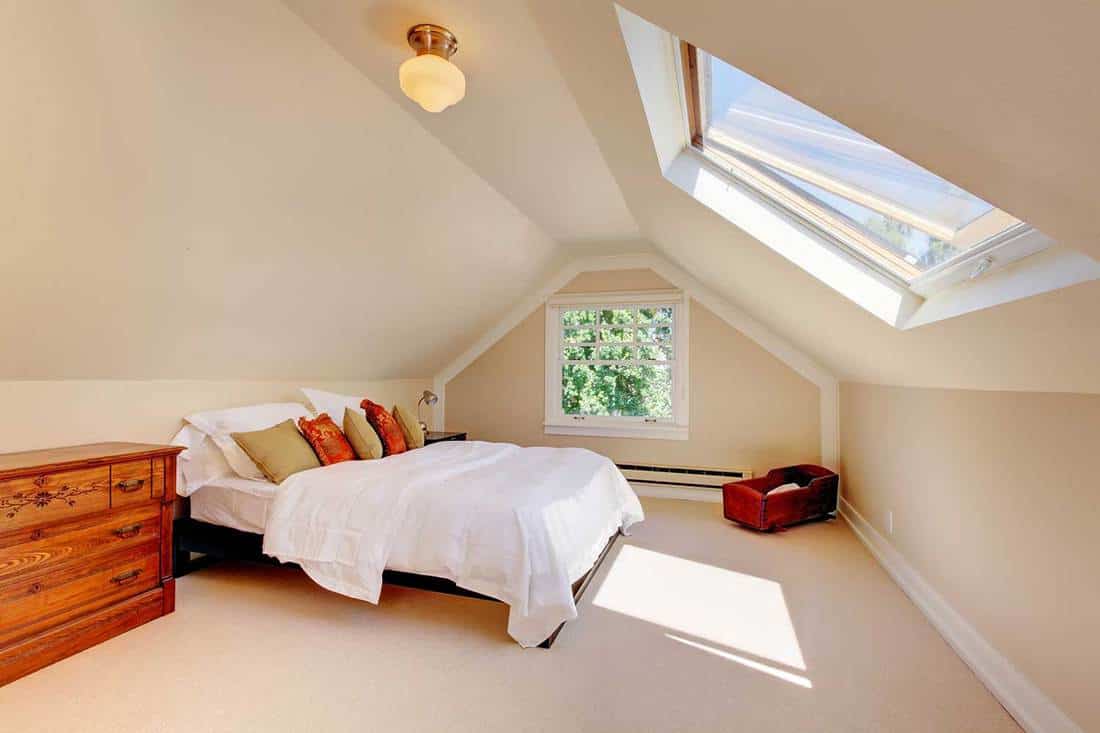 Attic modern bedroom with white bed and skylight
