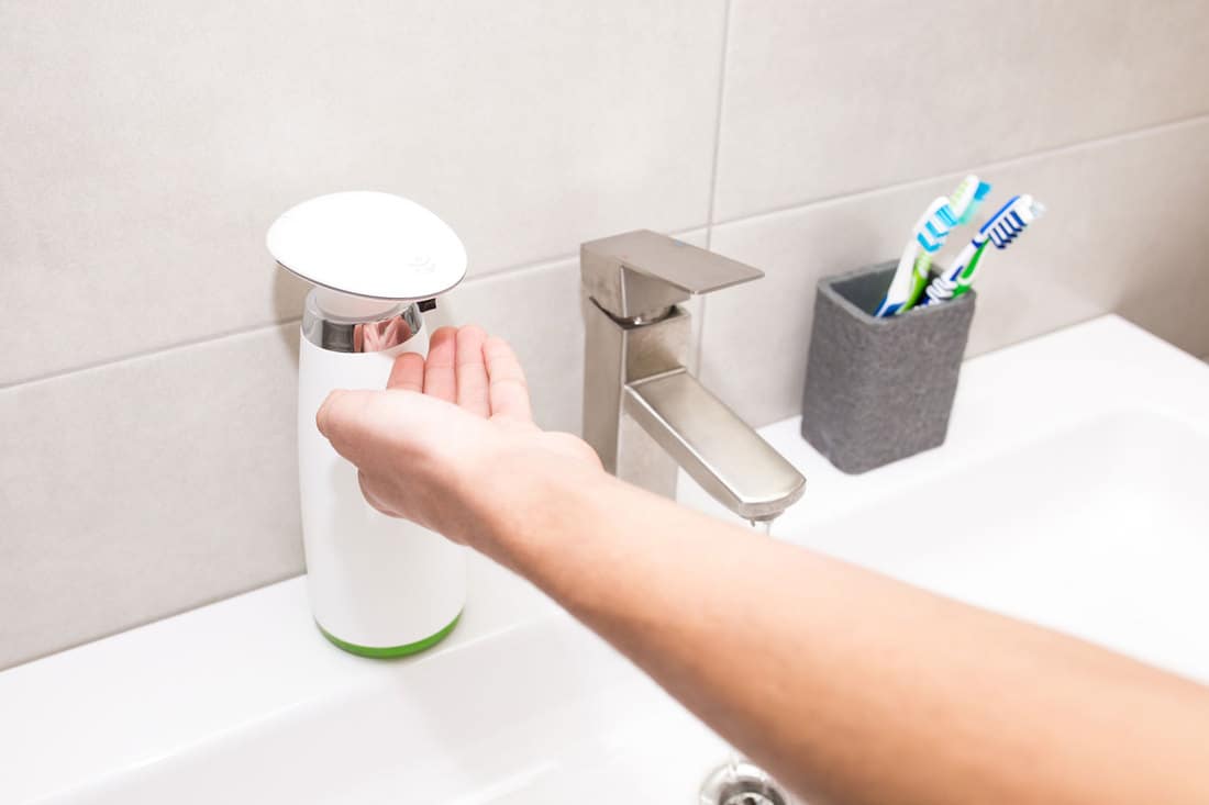 Distributeur automatique de savon liquide dans la salle de bain en gros plan, combien coûte un distributeur de savon automatique ?
