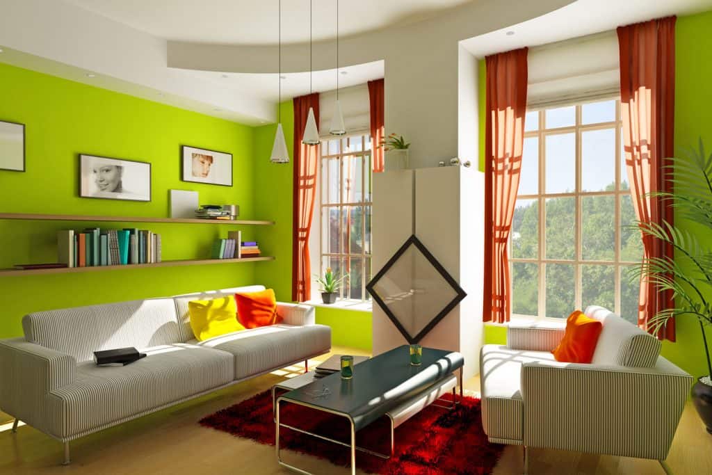 Beautiful living room with green walls, stripped leather sofas, wedged center table, and dangling lamps on the ceiling