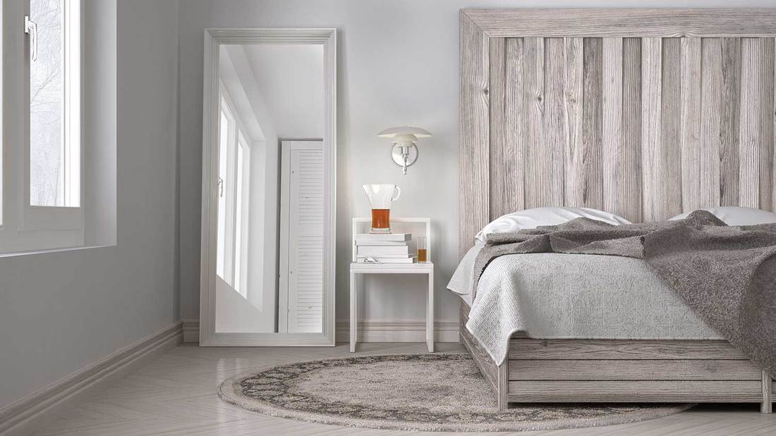 Bed with wooden headboard in Scandinavian white eco chic design bedroom