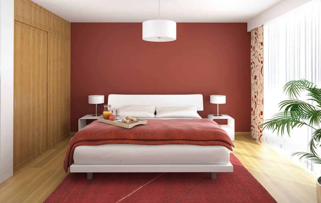Bedroom interior with red walls and beige curtains