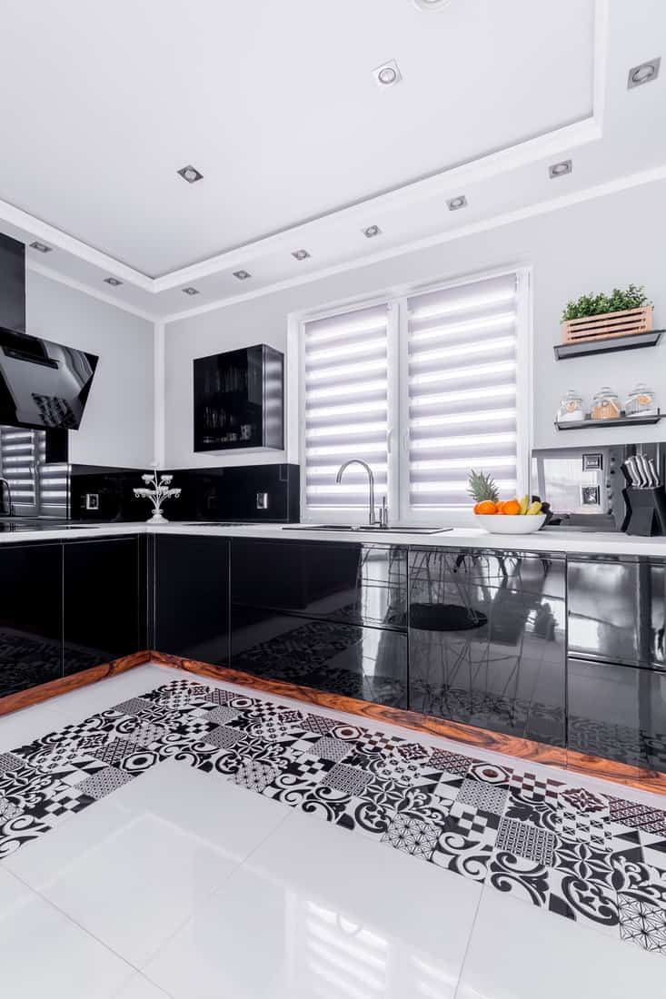 Black glossy modern kitchen countertop with sink and blinds