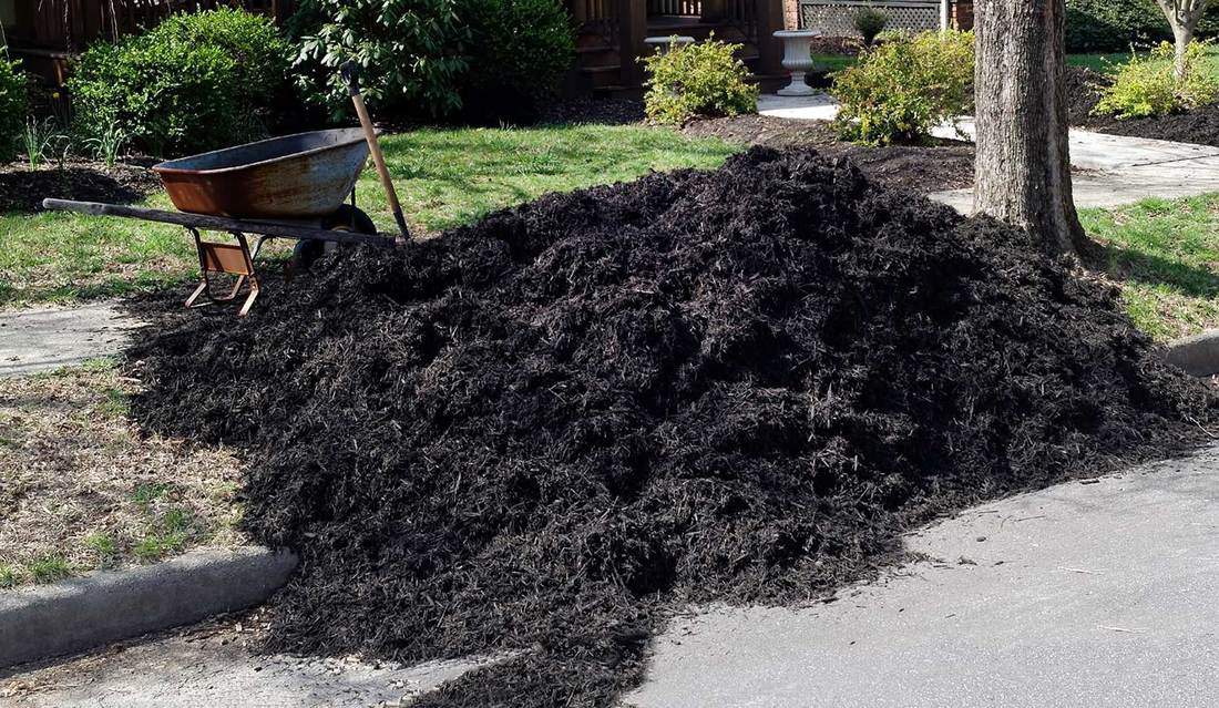 Black mulch piled on residential street easement
