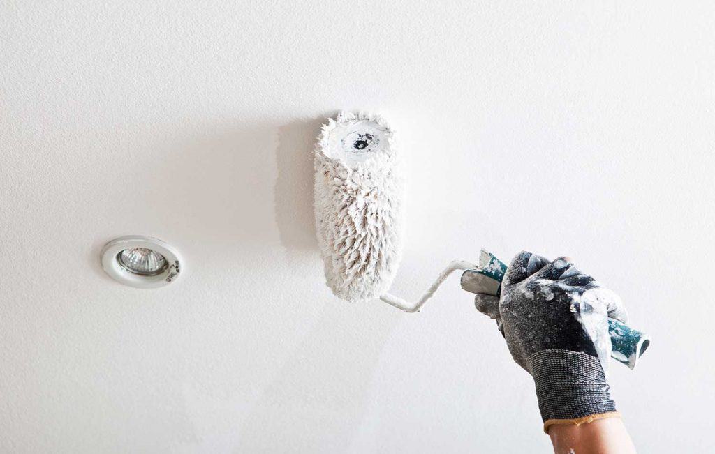 Close up of a painter hand painting a ceiling