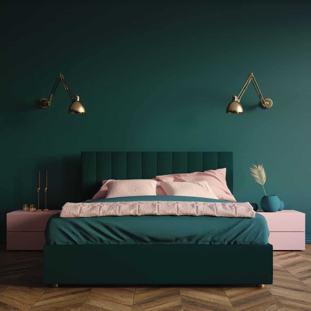 Contemporary interior of a modern bedroom with green and pink beddings and golden wall mounted lamps
