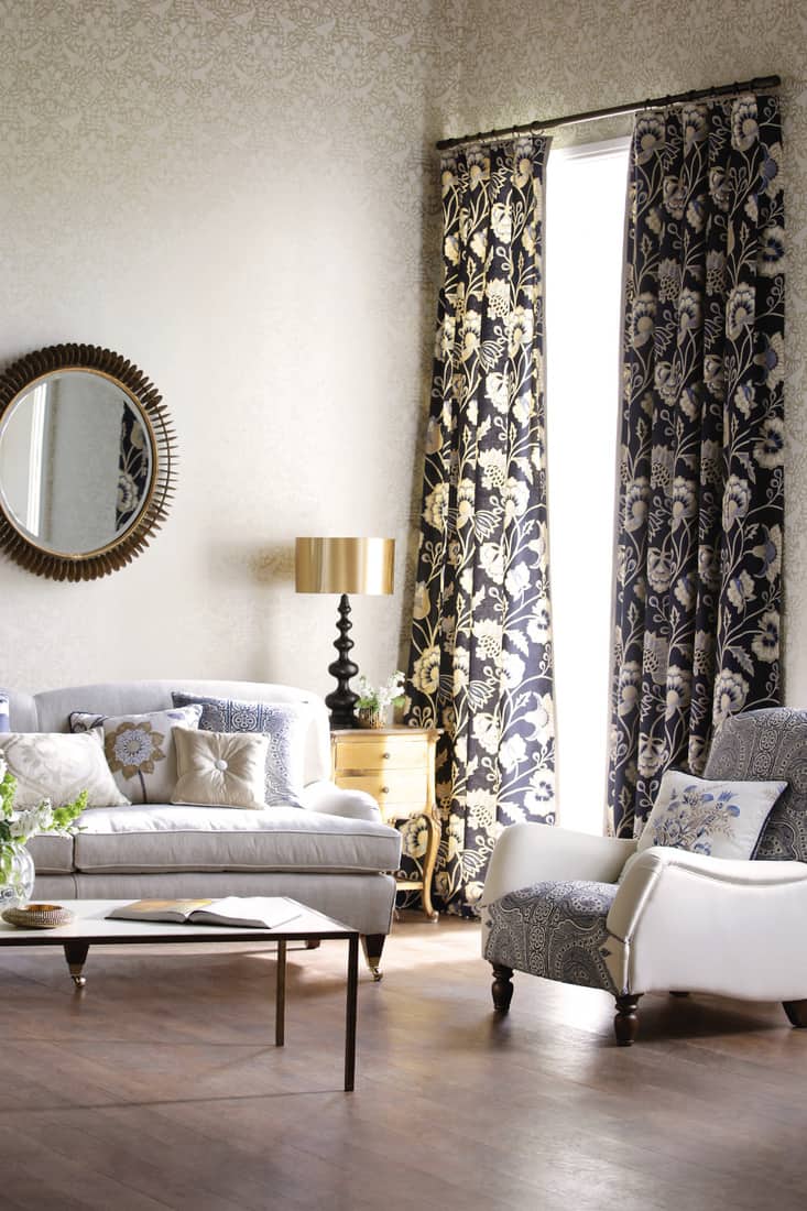 Contemporary lounge living room with sofa and ornaments in front of large window with curtains. Classy Cream And Black