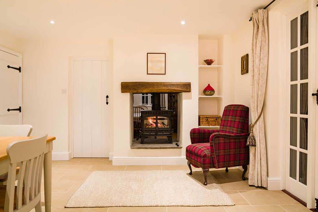 Country home interior, open plan room with wood burning stove in winter