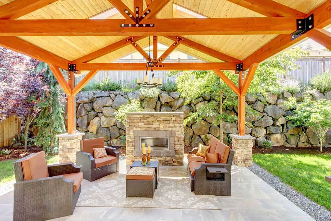 Exterior covered patio with fireplace and furniture