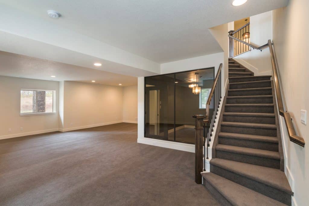Empty large room with carpet floor and carpeted stairs