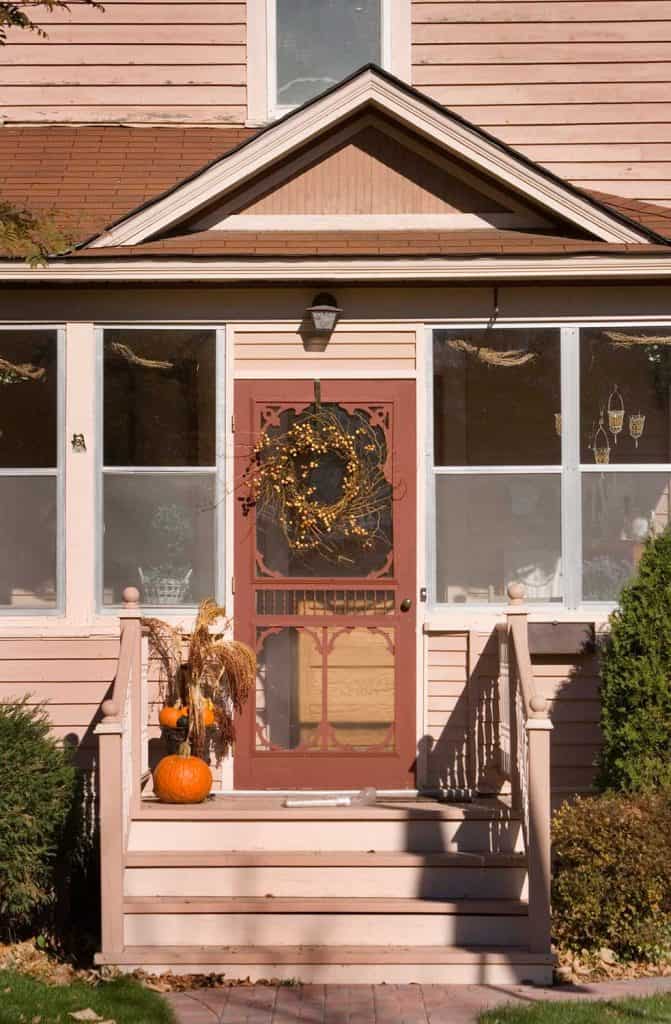 Front door of a quaint house decorated for fall