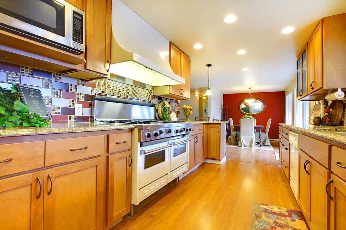 Furnished bright light brown kitchen room with wooden cabinets