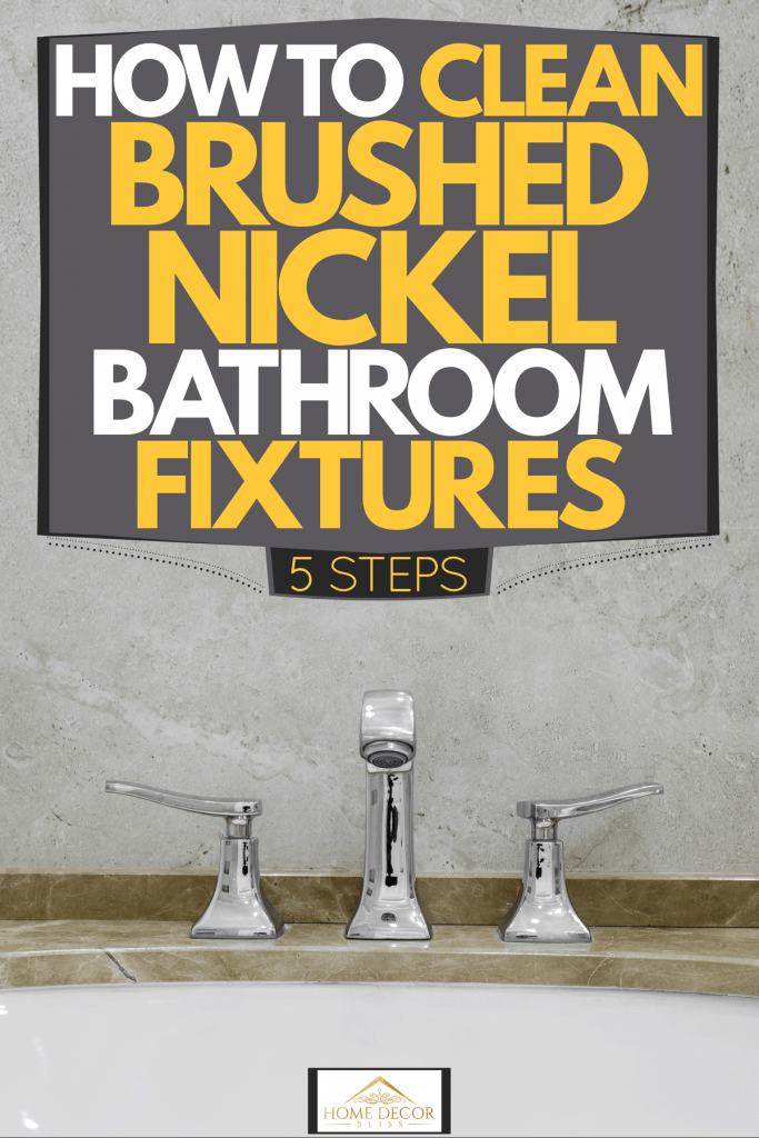 A brushed nickel finish faucet inside a modern bathroom with granite top layer bathtub, How To Clean Brushed Nickel Bathroom Fixture [5 Steps]