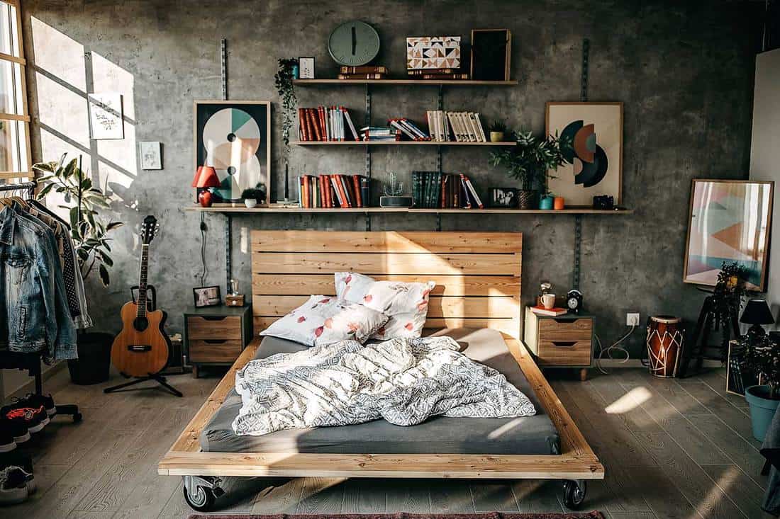Interior of modern bedroom in the sunny morning with clothes hanging on bar