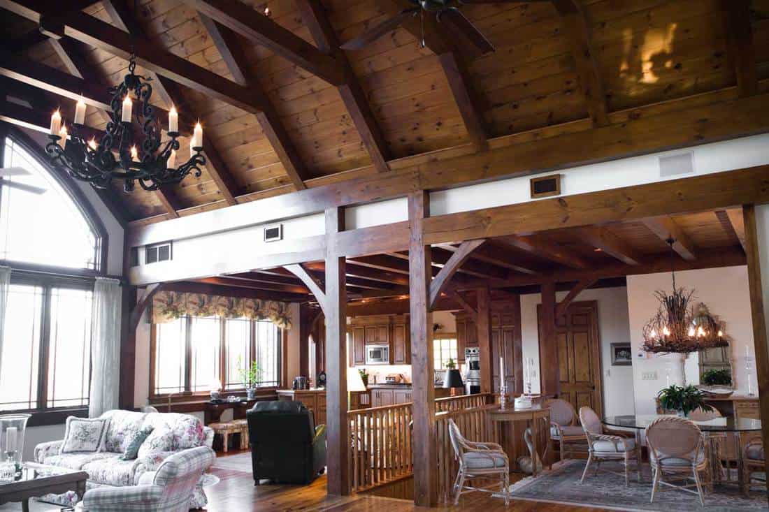 Living room with a beautiful stone fireplace and wooden beams, 17 Wood Ceiling Beams Ideas
