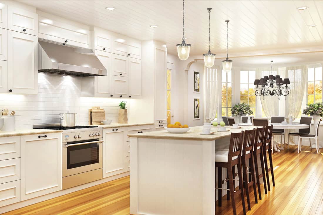 Cuisine blanche de luxe et salle à manger dans une grande maison avec des planchers en bois clair