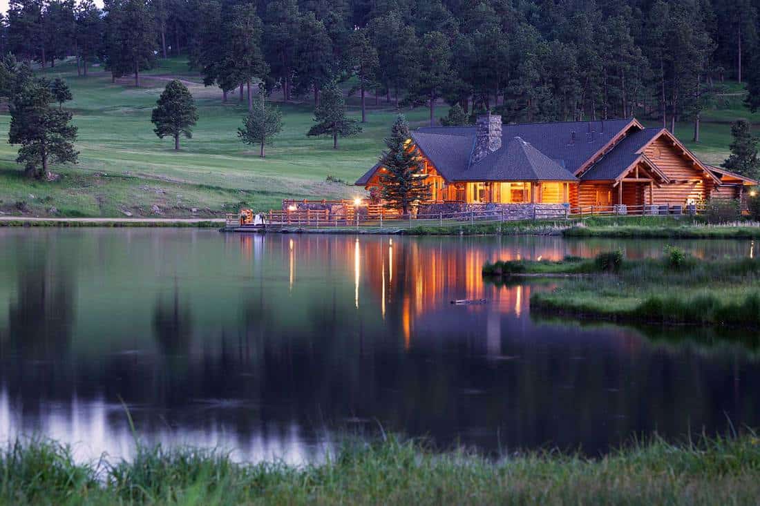 Mountain lodge reflecting in lake at dusk