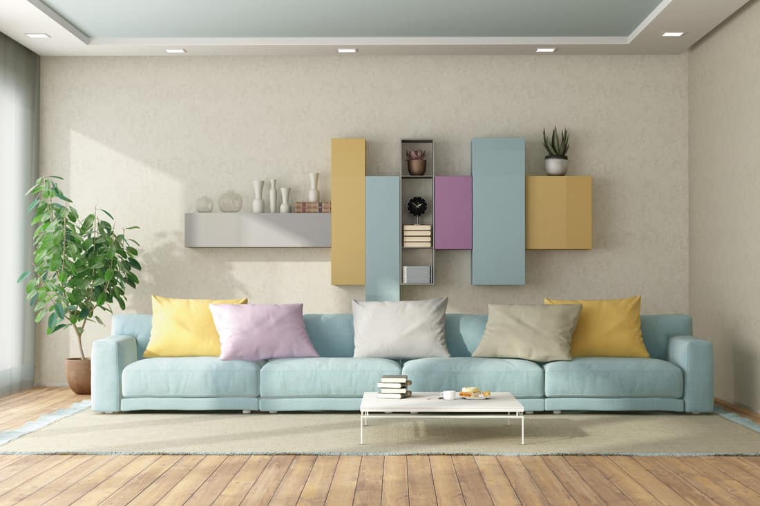 Pale Blue Ceiling With Lightest Linen Walls. Modern living room in pastel colors with sofa and bookcase on background